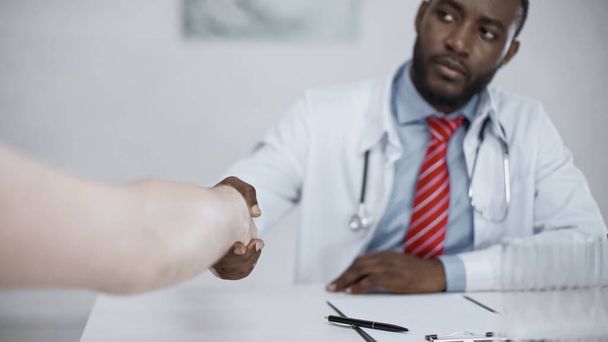 médico afroamericano estrechando la mano con el paciente  - Foto, Imagen