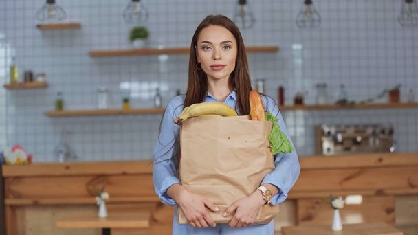 Bruneta žena drží balíček s jídlem doma  - Fotografie, Obrázek