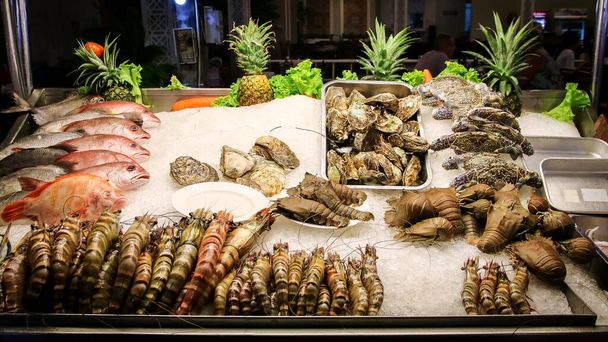 Ostrygi, raki, kraby, ryby i krewetki na tacy lodowej w ulicznej restauracji owoców morza - Zdjęcie, obraz