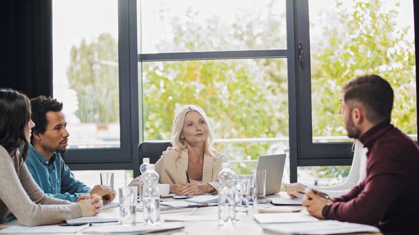 středního věku podnikatelka mluvit s různými manažery během setkání v kanceláři - Fotografie, Obrázek