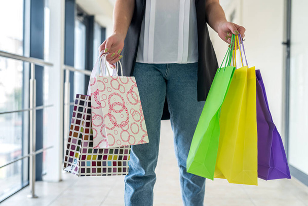 ショッピングセンターの黒い金曜日の中にショッピングバッグを持つ若い女性。販売と割引  - 写真・画像