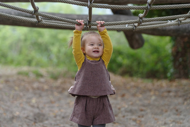 A 18 months old baby girl in a playground outdoors - Photo, Image