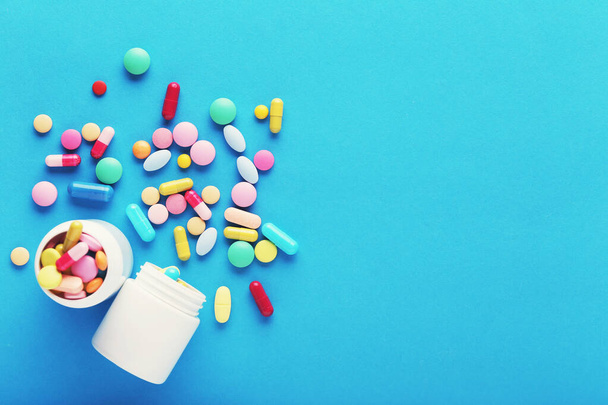 Colorful pills and bottles on blue background - Photo, Image