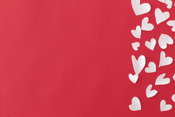 ¡Feliz San Valentín! Elegantes corazones bordean sobre fondo rojo plano yacen con espacio para el texto. Día de San Valentín. Lindos corazoncitos blancos cortados en papel rojo. Tarjeta de felicitación plantilla - Foto, Imagen
