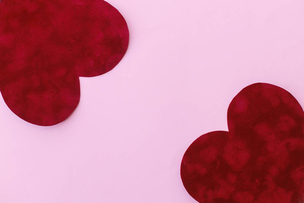 ¡Feliz San Valentín! Elegantes corazones de San Valentín sobre fondo rosa plano yacía con espacio para el texto. Plantilla de tarjeta de San Valentín. Lindo corazón de terciopelo rojo sobre papel rosa. Concepto de amor - Foto, imagen