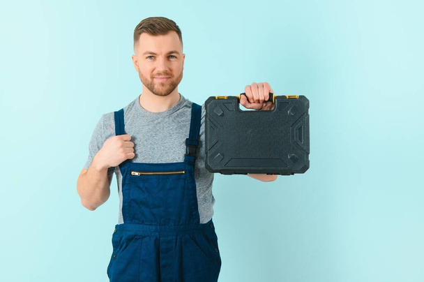 Portrait of smiling worker in uniform isolated on blue background - Foto, afbeelding