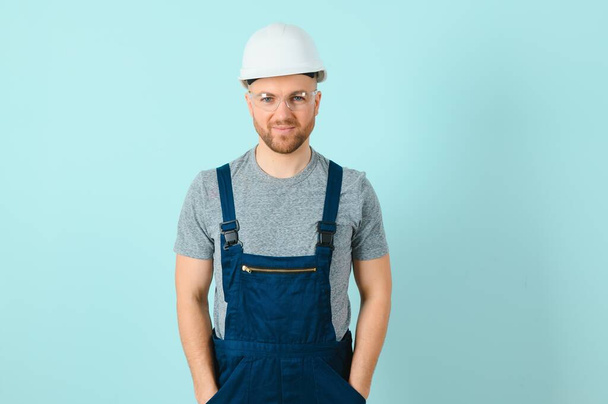 Handsome young craftsman over isolated blue background - Zdjęcie, obraz