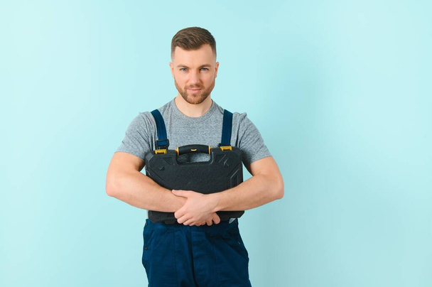 Handsome young craftsman over isolated blue background - Foto, afbeelding