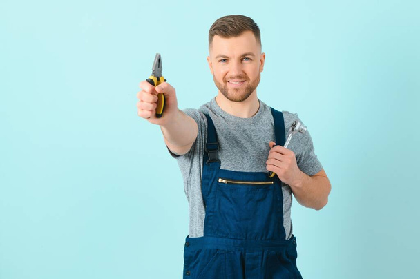 Portrait of a friendly worker. Isolated on blue - Photo, Image
