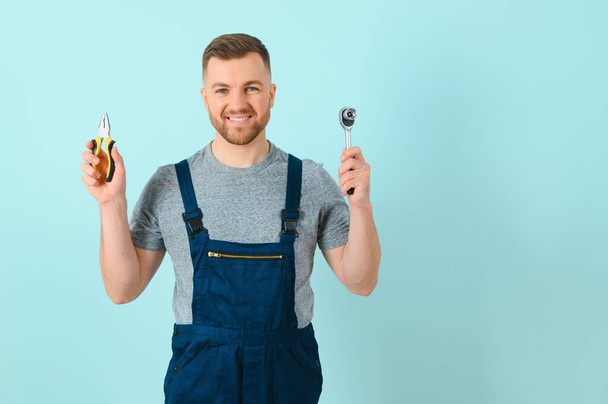 Handsome young craftsman over isolated blue background - Φωτογραφία, εικόνα