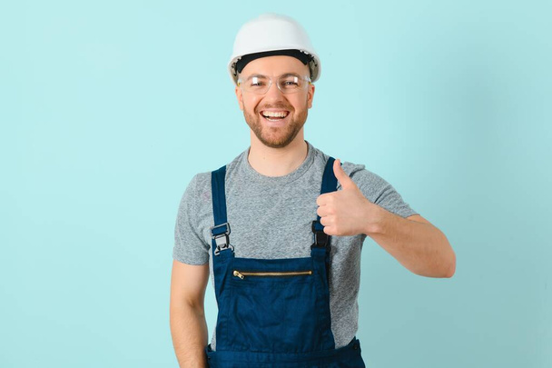 Close-up portrait of his he nice attractive cheerful cheery content guy repairer craftsman isolated over blue color background. - Foto, Bild