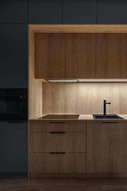 Modern and small kitchen with wooden furniture and floor and led light - Zdjęcie, obraz