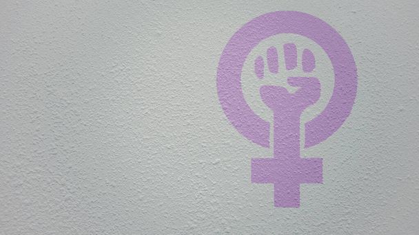 白いドリップ壁の背景にあなたのプロモーションテキストや広告のための横にコピースペースを持つ女性の性別で育った強い拳の図面。フェミニズムのシンボルコンセプト - 写真・画像