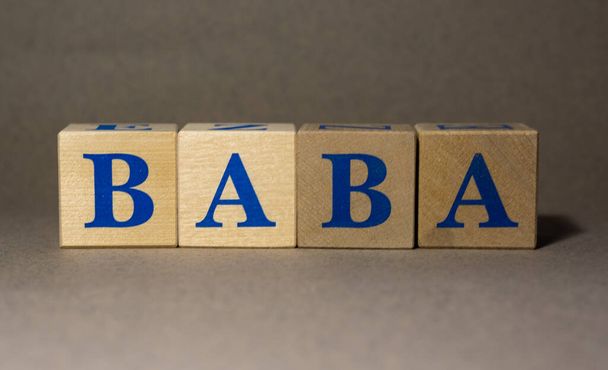 January 19, 2022. New York, USA. Exchange Ticker symbol of the company Alibaba Group BABA, made of wooden cubes, on a gray background. - Foto, imagen