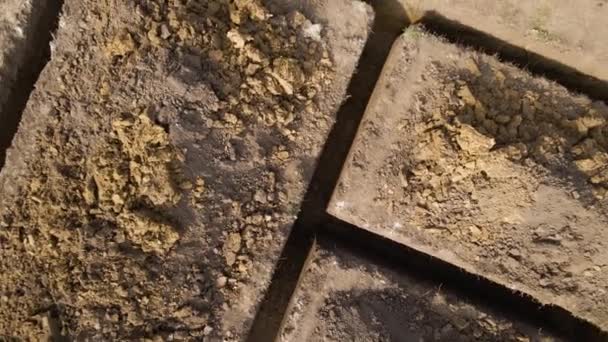 Σκάψιμο τάφρου για οικοδομικές εργασίες νέων κατοικιών σκυροδέματος θεμελίωσης σε εργοτάξιο - Πλάνα, βίντεο