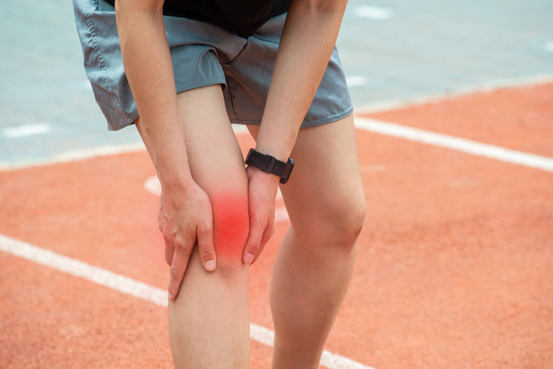 Gros plan de la coureuse tenant son genou, souffrant de douleurs au genou après avoir couru. Conceptuel de blessure lors de la course à pied. - Photo, image