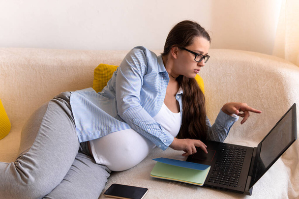 Successful hardworking Pregnant business Woman With Laptop and Noutbook. Young Ledy In Pregnancy Work conducts an online conference lesson Remotely Using Technology At Home. Maternity leave Concept - Fotoğraf, Görsel