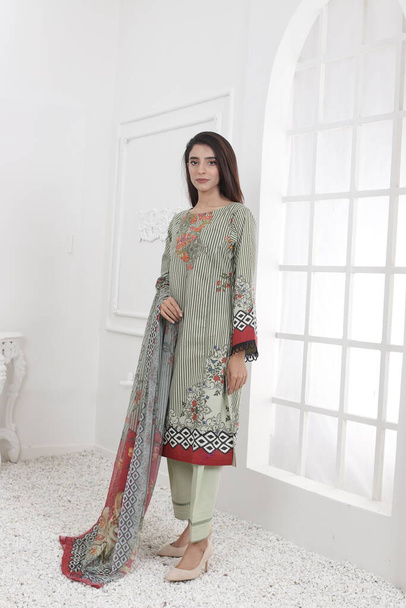 Пакистанский костюм шалвара Камиза с дупаттой. Пакистанской модели показывается ее платье со стилем. - Фото, изображение