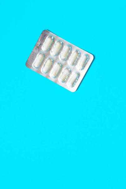 Blasen mit weißen Pillen auf blauem Hintergrund. Hochwertiges Foto - Foto, Bild