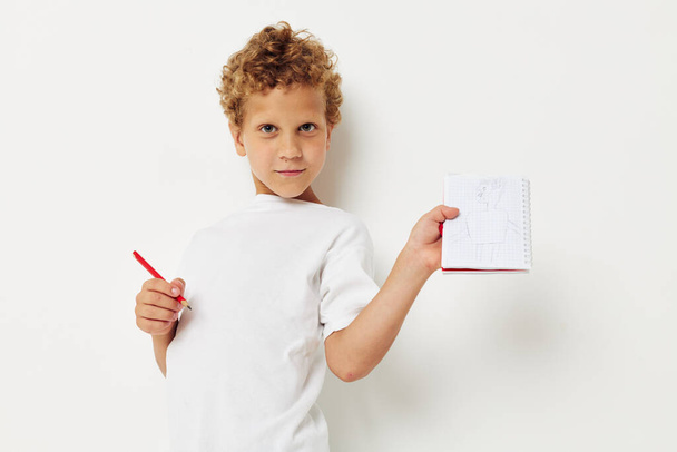 Boy draws with pencil in notebook entertainment studio - 写真・画像