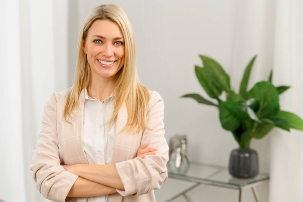 Successful confident young female entrepreneur or businesswoman in casual clothes standing with arms folded in the office - Photo, Image
