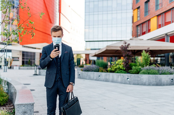 Young man in formal wear using smartphone in city - Фото, зображення