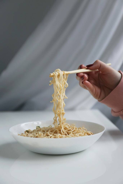person holding a bowl of noodles - Fotó, kép