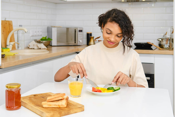 Young african american woman having traditional breakfast at home - Fotografie, Obrázek