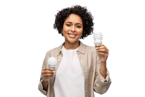 happy smiling woman holding lighting bulbs - Fotografie, Obrázek