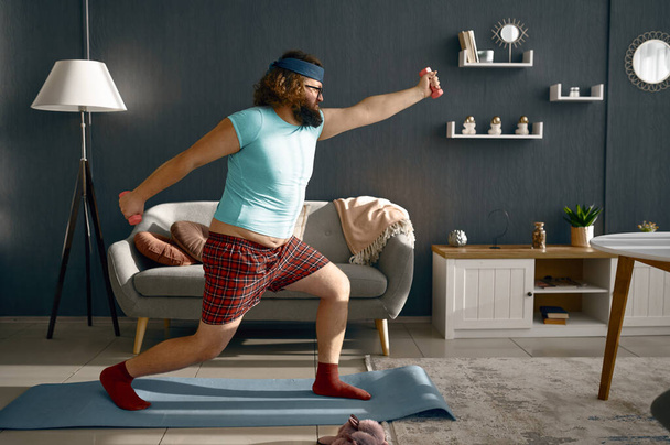 Hombre divertido haciendo ejercicio matutino con pesas - Foto, Imagen