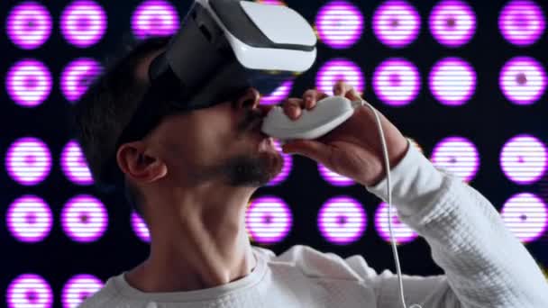 Hombre con gafas de realidad virtual hace tostadas y bebidas alcohólicas  - Metraje, vídeo