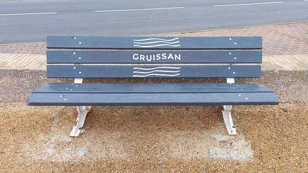 Gruissan miasto francuski tekst na drewnianej ławce w mieście ulicy w południowej Francji Occitanie - Zdjęcie, obraz