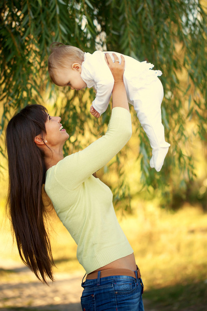Happy mother and baby playing outdoors.  - Zdjęcie, obraz