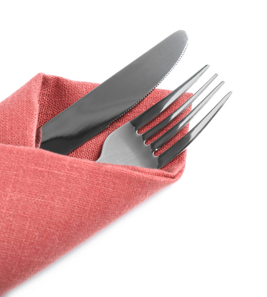 Fork and knife wrapped in coral napkin on white background, top view - Foto, Bild