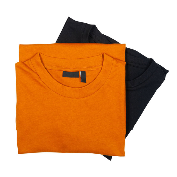 two male folded t-shirts orange and black isolated on white - Fotoğraf, Görsel