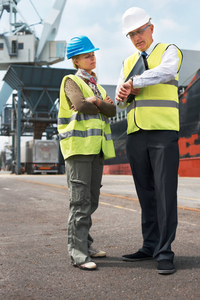 Time is of the essence.. Two engineers discussing planning on a site while in the shipyard. - Photo, Image