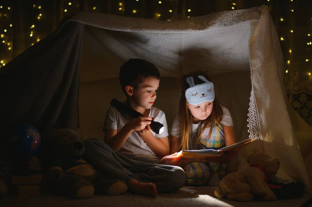 Niños pequeños leyendo cuentos para dormir en casa
 - Foto, Imagen