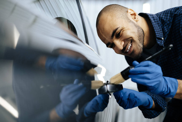 Afro-Américain travailleur de service de voiture appliquant nano revêtement sur une voiture - Photo, image