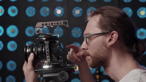 Pazzo regista di cameraman guarda nella fotocamera e emotivamente commenti processo - Filmati, video