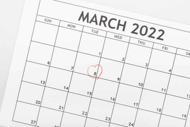 top view of march 2022 calendar with drawn heart around 8 march date isolated on white - Foto, imagen