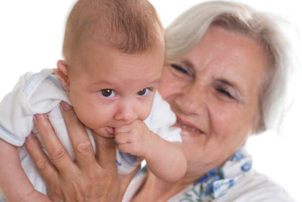 Elderly woman holding a newborn - Foto, afbeelding