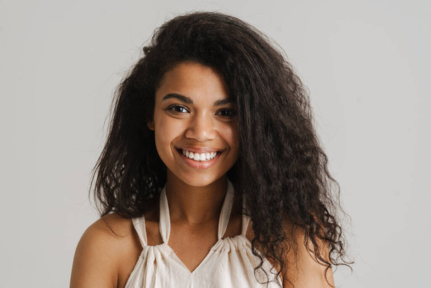 Black young woman in dress smiling and looking at camera isolated over white background - Photo, Image