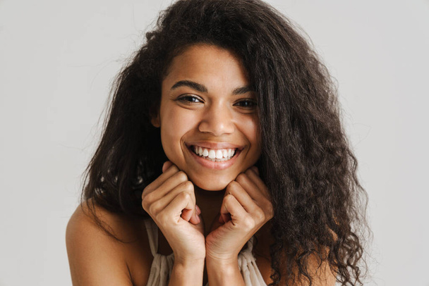 Black young woman in dress smiling and looking at camera isolated over white background - Foto, Imagem