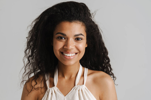 Black young woman in dress smiling and looking at camera isolated over white background - Zdjęcie, obraz
