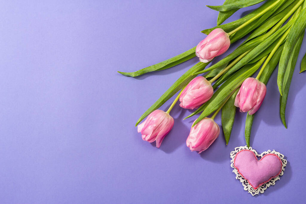 ピンクの背景にチューリップの花束の近くのグリーティングカードのトップビュー ロイヤリティフリー写真 画像素材