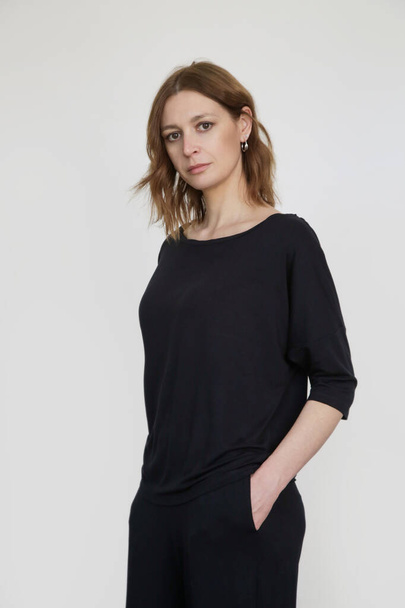 黒の綿のカジュアルな服装で女性のスタジオショット,半袖シャツと基本的なパンツ - 写真・画像