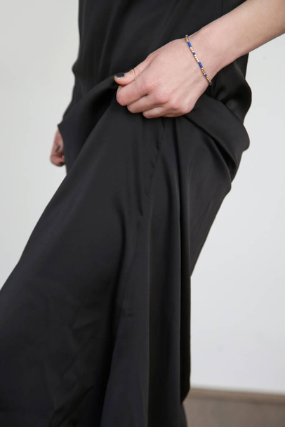 Woman in black silk satin camisole dress, studio shot. - Fotó, kép