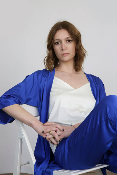 Kobieta w jedwabnym królewskim niebieskim szlafroku i białej koszuli, studio shot. - Zdjęcie, obraz