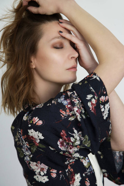close-up studio portret van brunette in donker bloemengewaad jurk, studio schot. - Foto, afbeelding
