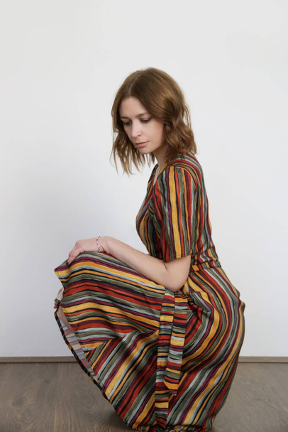 Woman in funky multicolor striped wrap midi dress. Studio shot. - Foto, Imagem